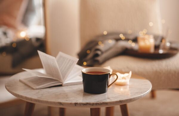 Sunlight shining into a cozy room with a mug and notebook on a small table